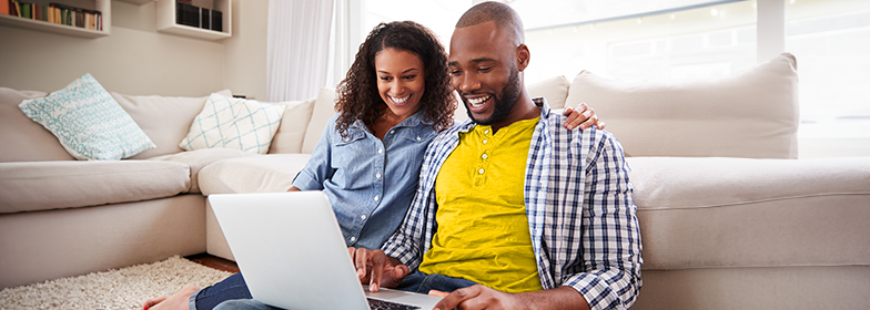 Smiling couple looking at laptop