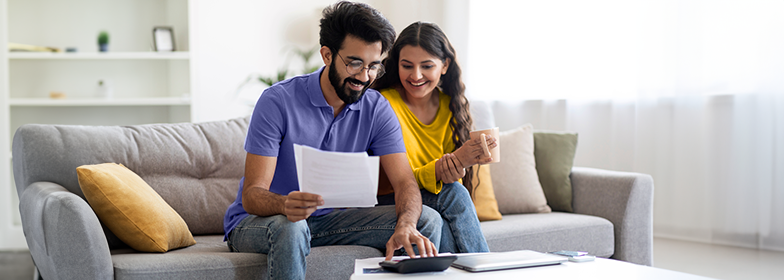 Couple on couch looking at documents