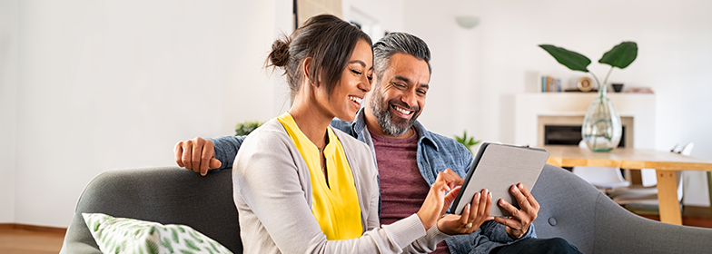 Couple looking at tablet on couch