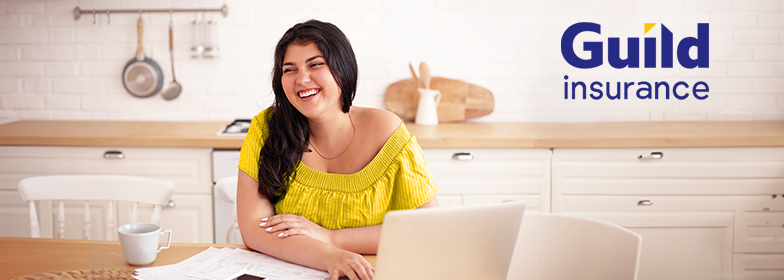 Smiling woman with laptop and inset Guild Insurance logo