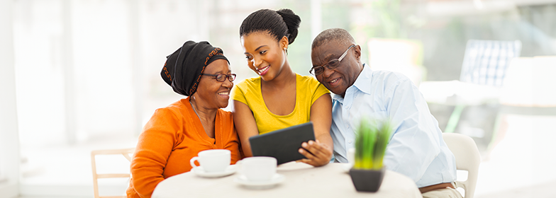 Smiling daughter looking at tablet with parents