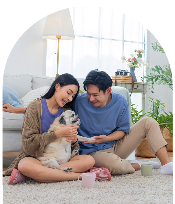 Couple sitting on floor playing with dog