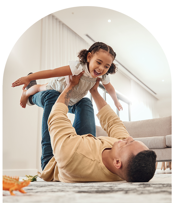 Father picking up smiling daughter